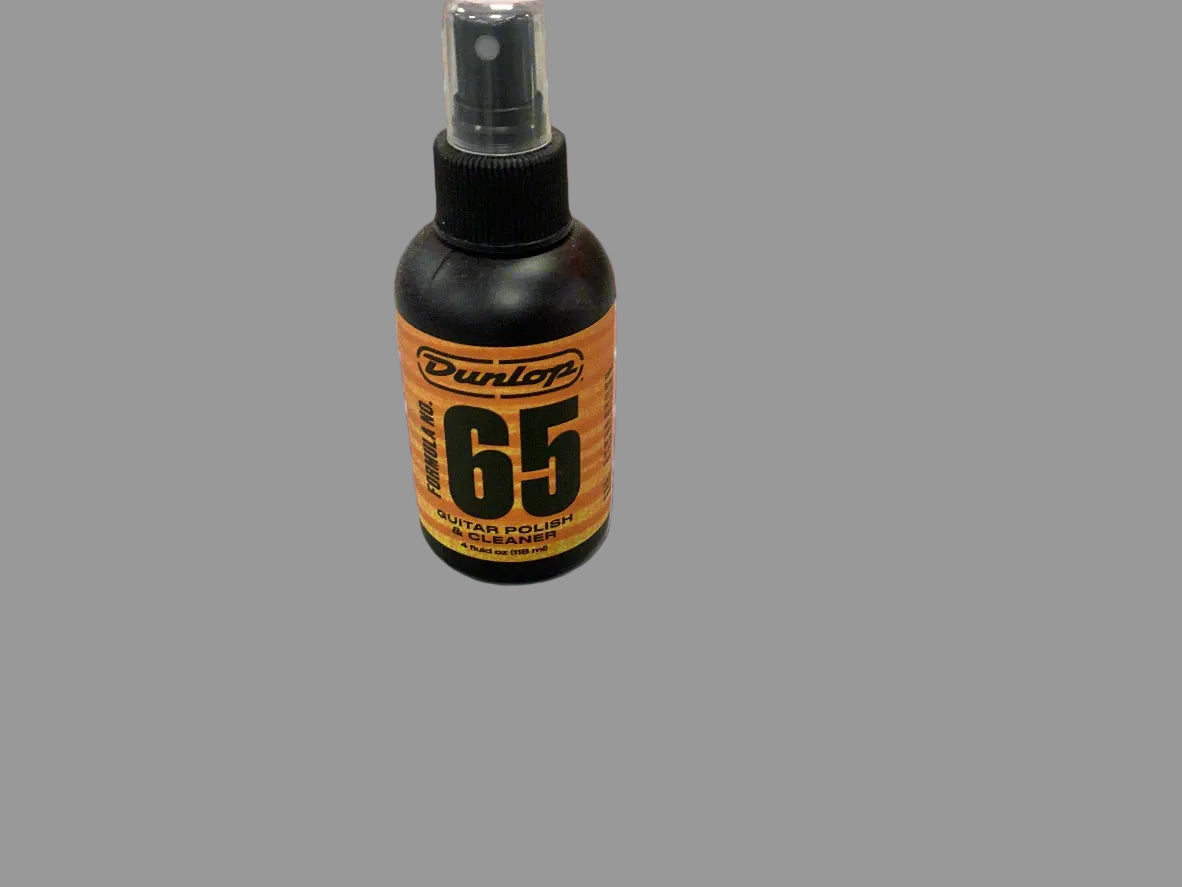 Image of A bottle of Dunlop 65 guitar polish with a spray dispenser, placed on a flat surface.