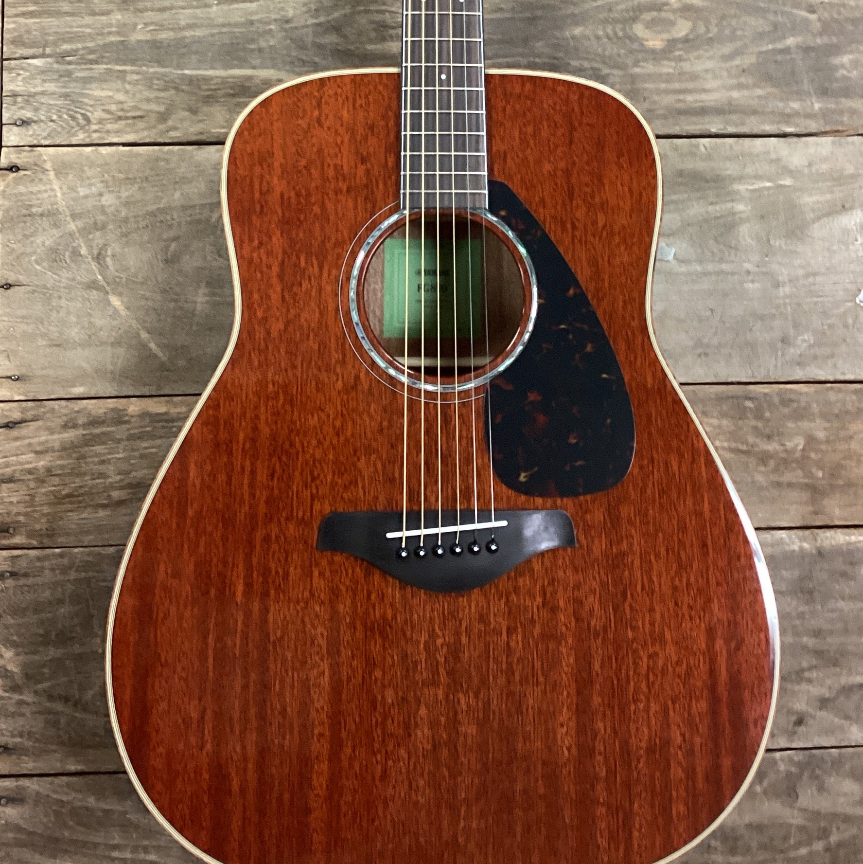 Image of Acoustic guitar leaning against a wooden wall