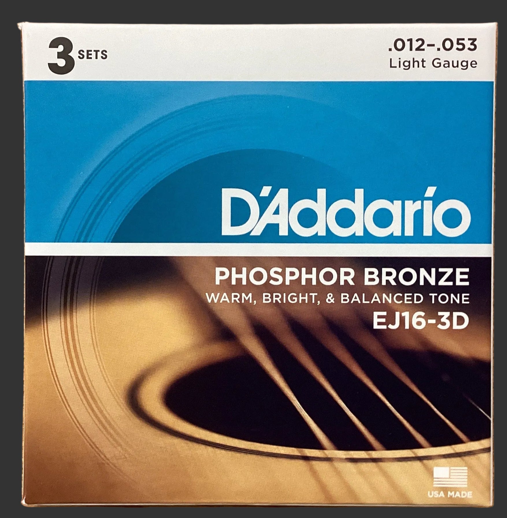 Image of D'Addario phosphor bronze guitar string set packaging on a wooden surface