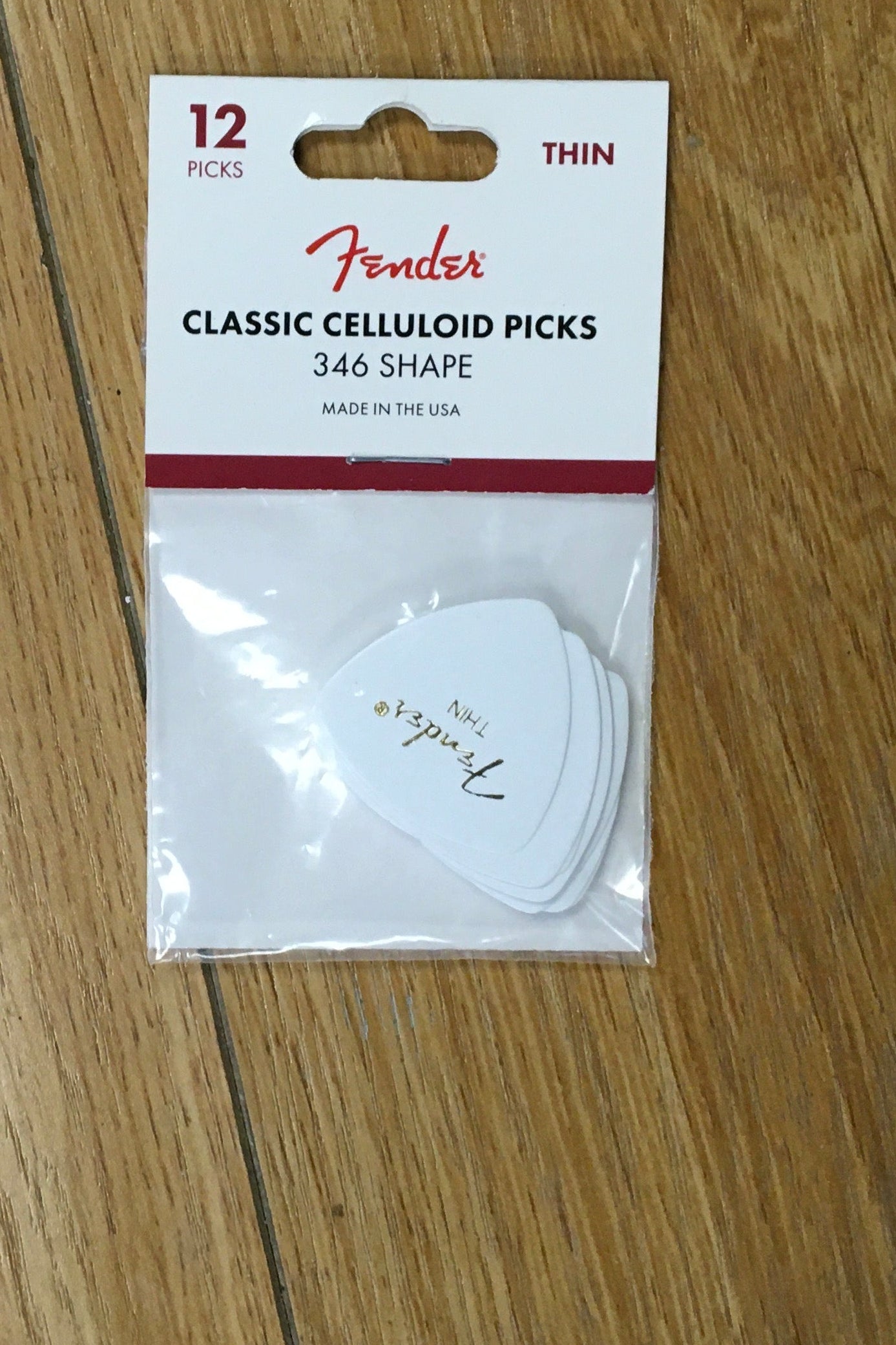 Image of Pack of Fender guitar picks on a wooden surface