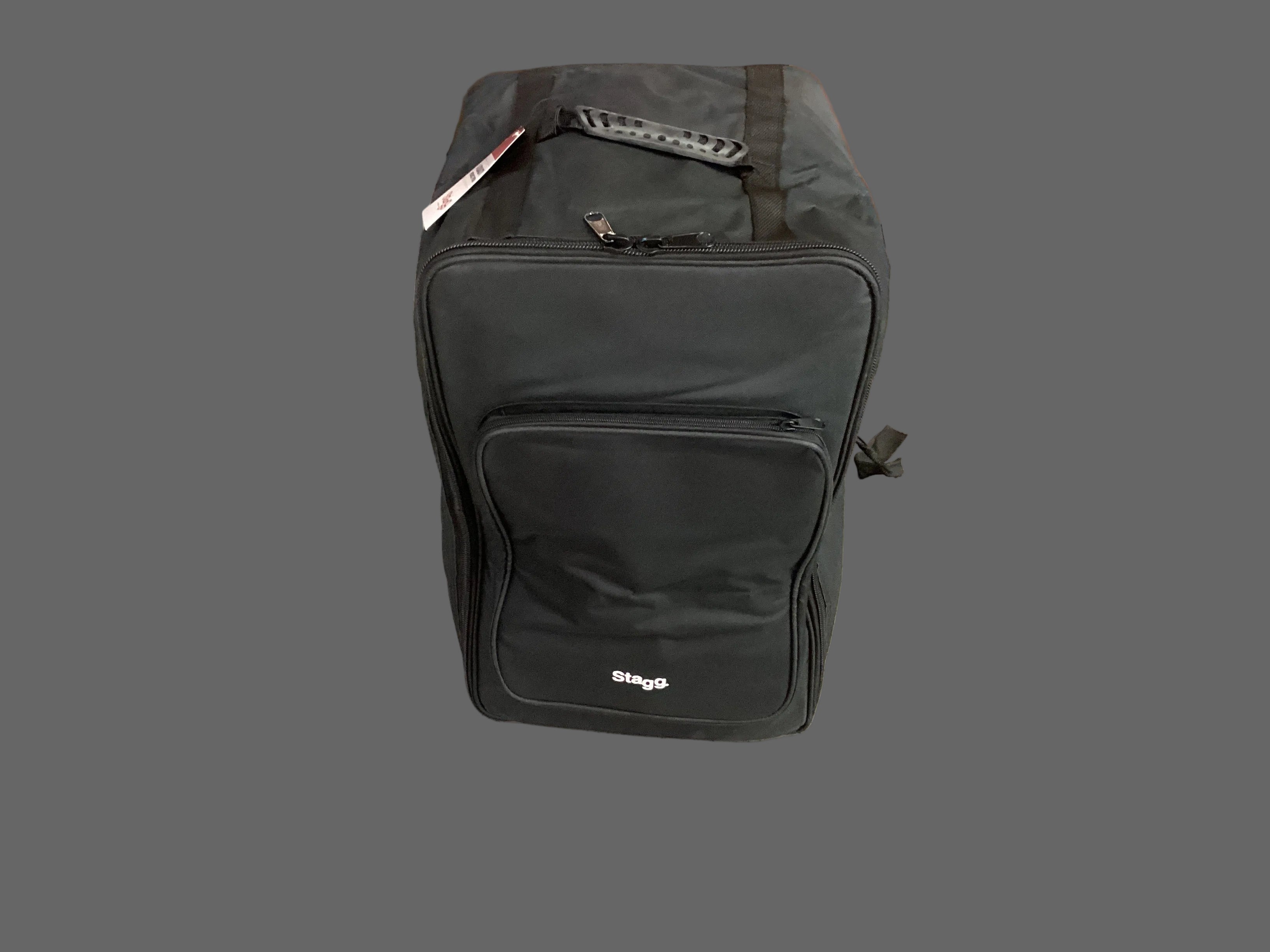 Image of A black STAGG branded cajon bag placed on a tiled floor, with its handle up and wheels visible.