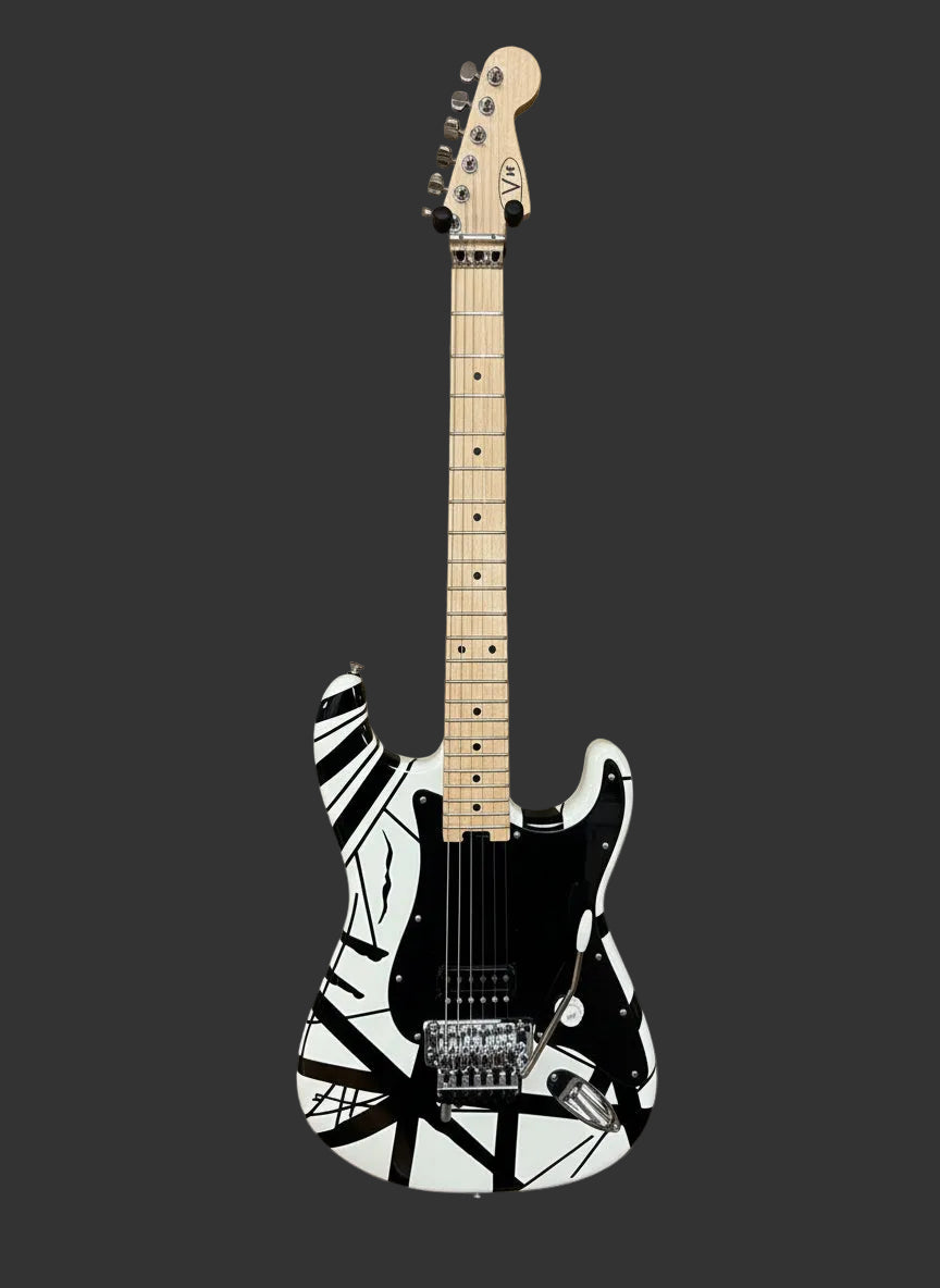 Image of Black and white EVH guitar against wood boards