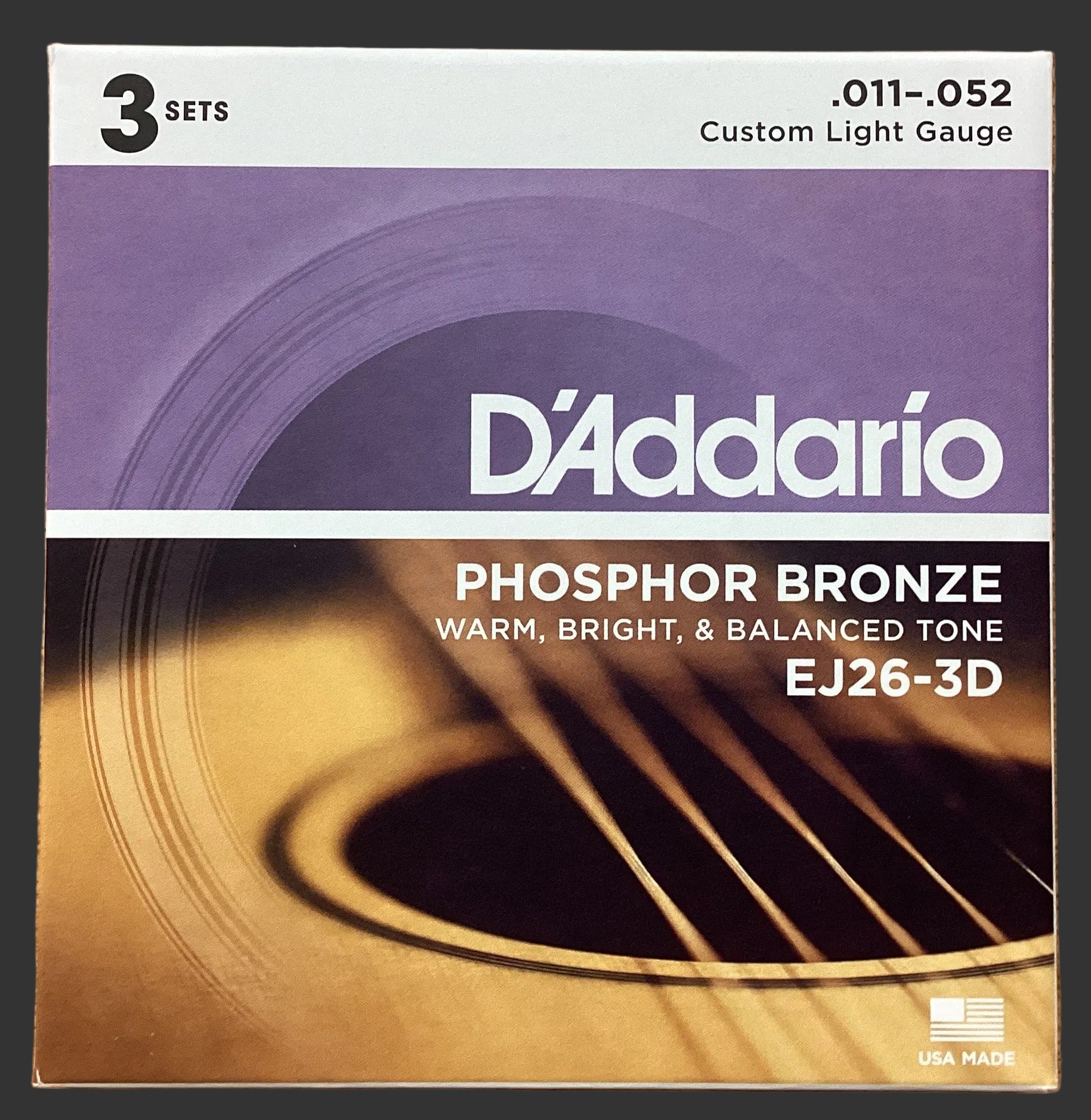 Image of D'Addario phosphor bronze acoustic guitar strings packaging on a wooden surface