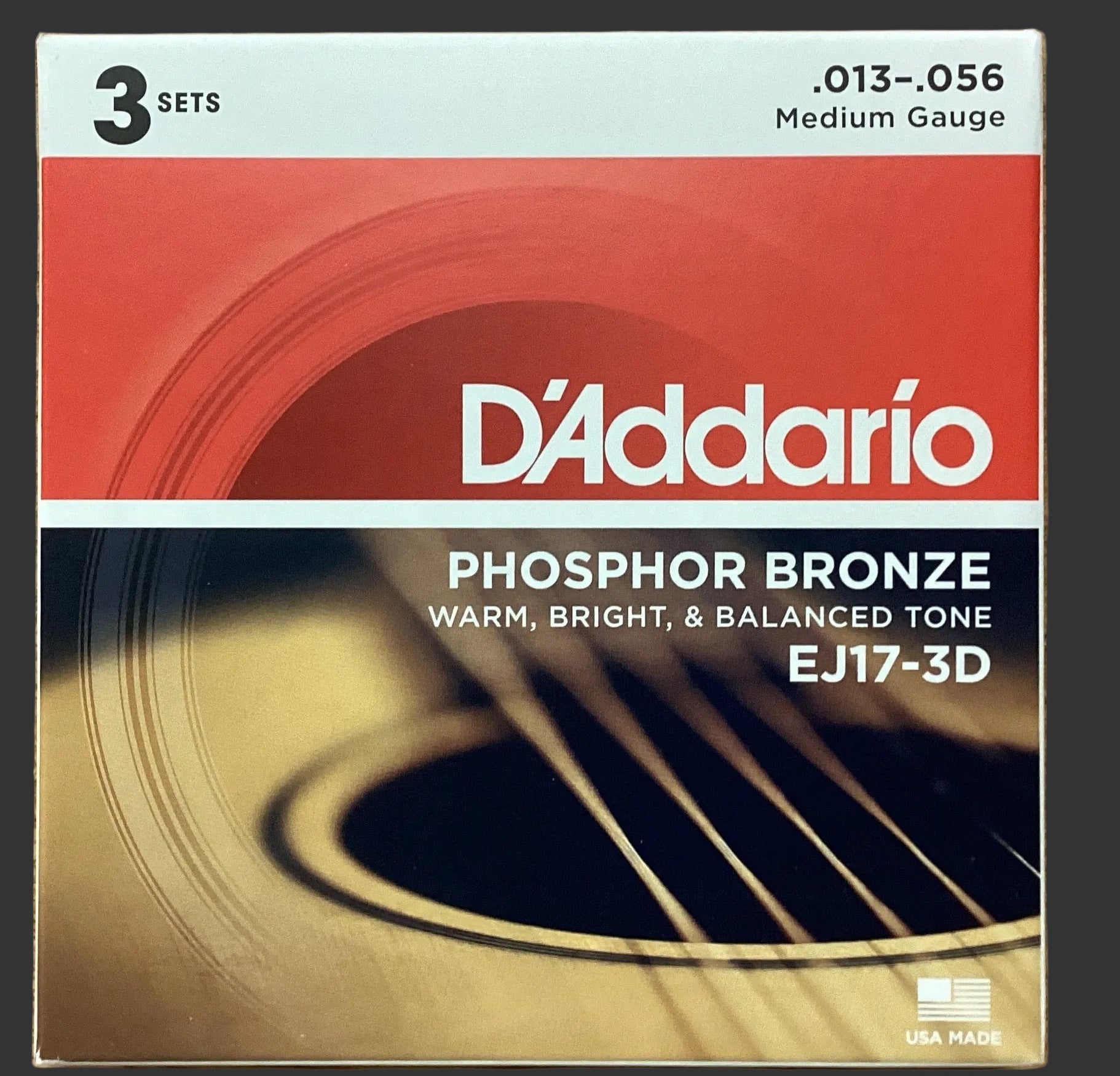 Image of D'Addario phosphor bronze guitar string set packaging on a wooden surface
