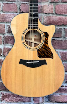 Image of Acoustic guitar against a brick wall