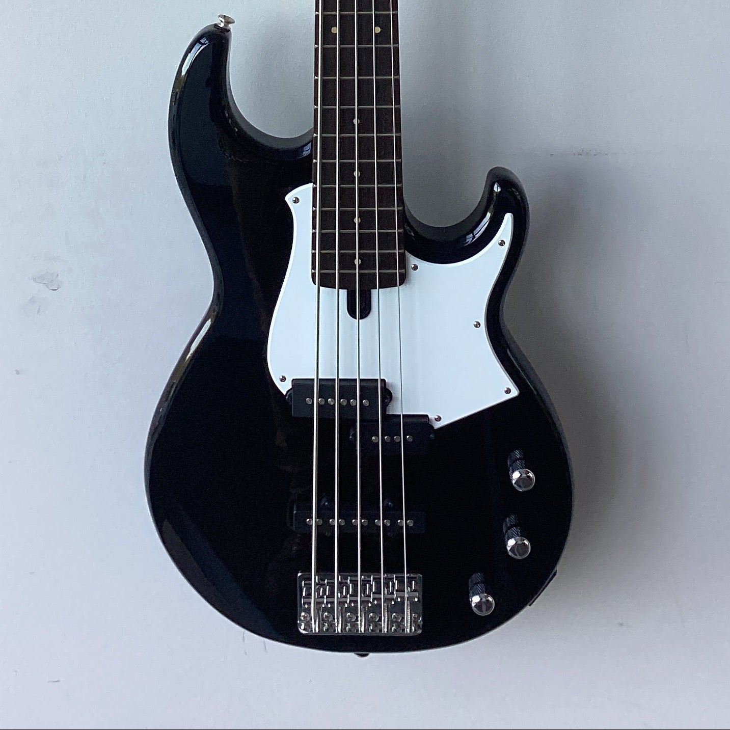 Image of Black electric bass guitar on a white background