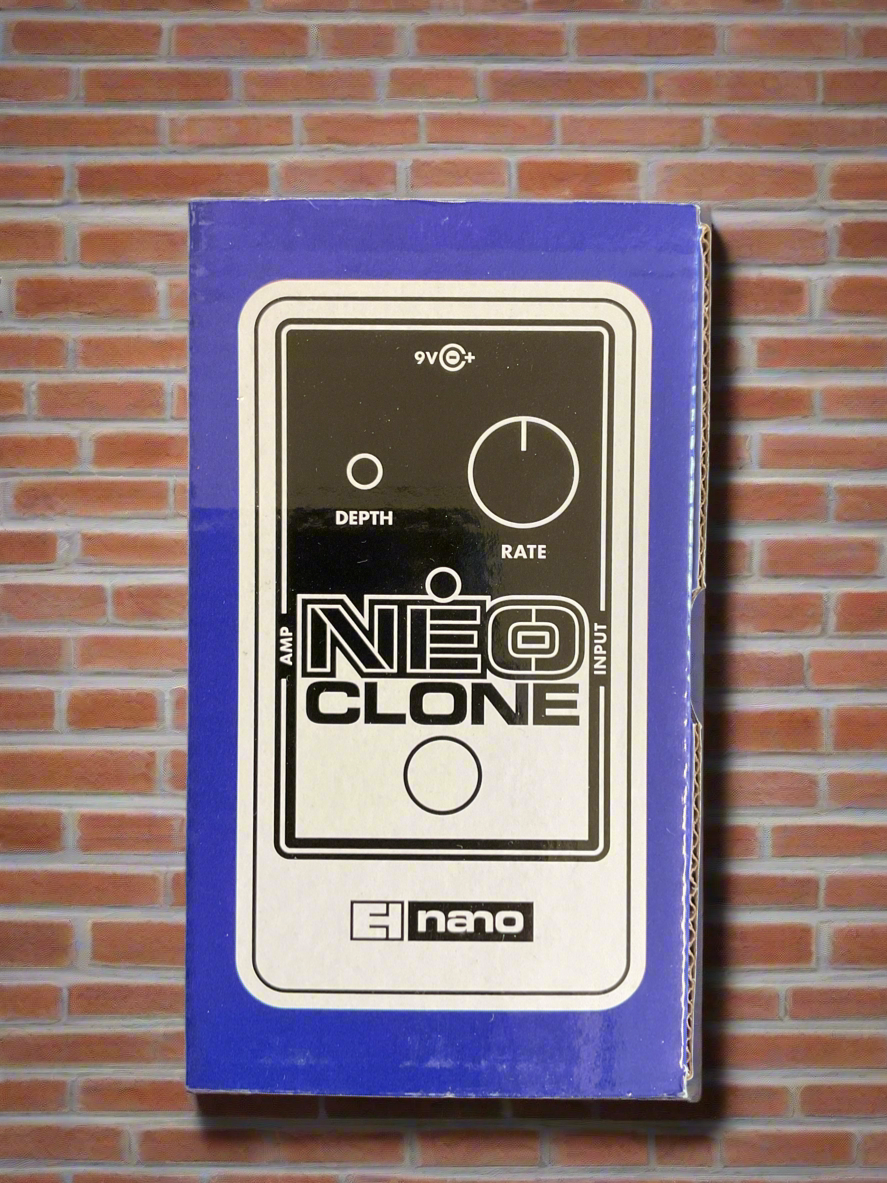 Image of Electro-Harmonix NEO CLONE pedal in its packaging, featuring a black and white image of the pedal with knobs for depth and rate, placed against a brick wall backdrop.