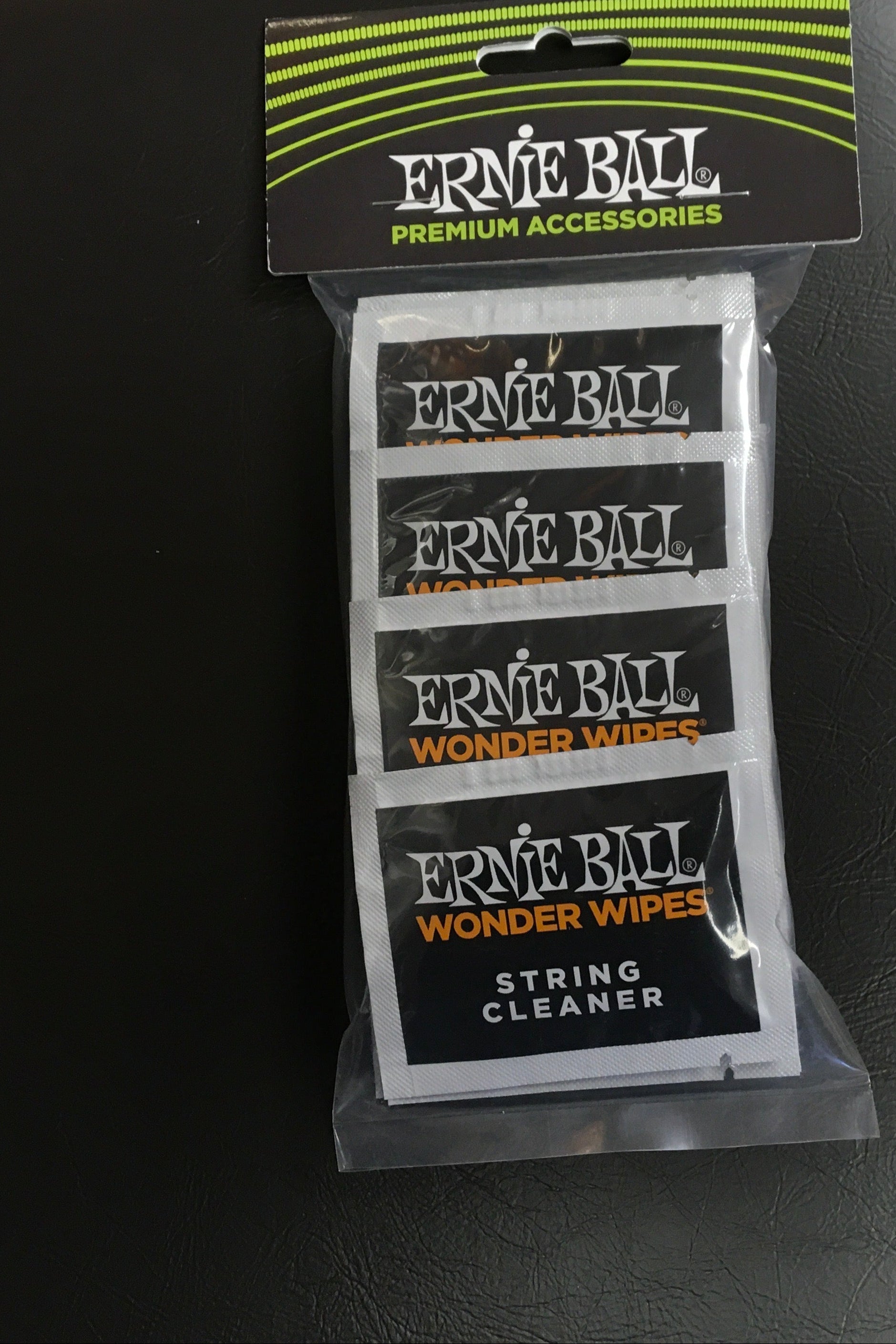 Image of Ernie Ball string care products on a black surface