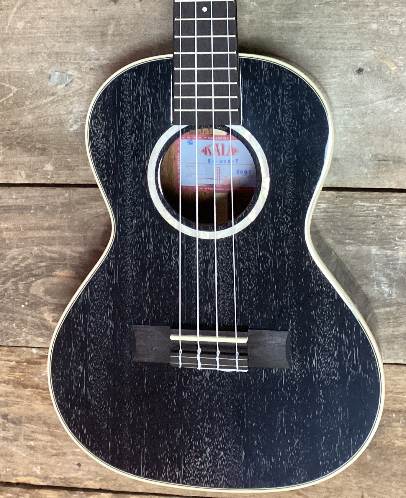 Image of Acoustic guitar with a tag on a wooden surface