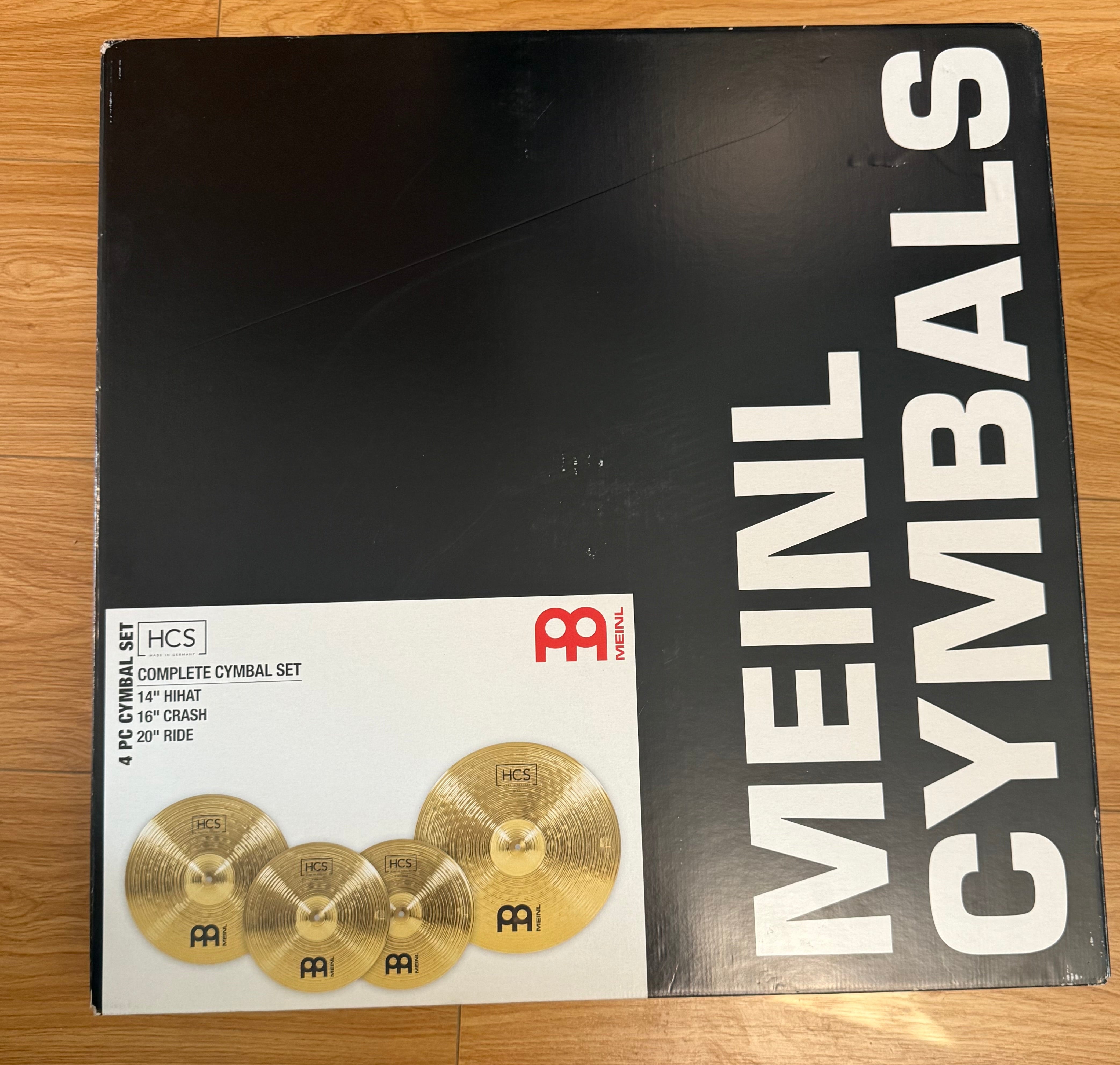 Image of Box of Meinl Cymbals with a smaller image of cymbals on a wooden surface