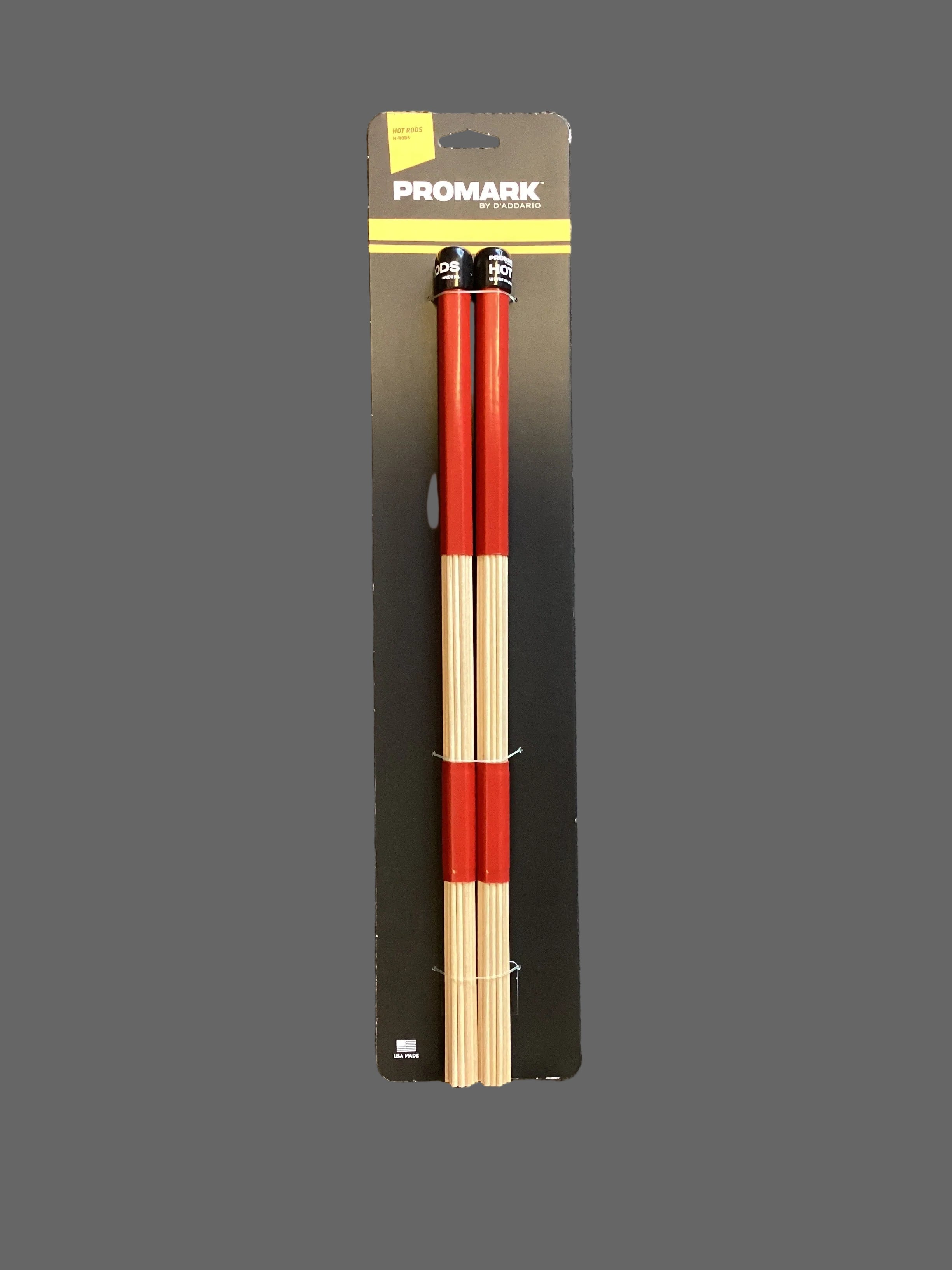 Image of A pair of Promark Hot Rods Multi Rods drumsticks laid out on a flat surface, predominantly red with white and black detailing.