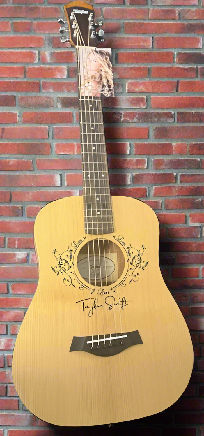 Acoustic guitar with Taylor Swift's name on a black background